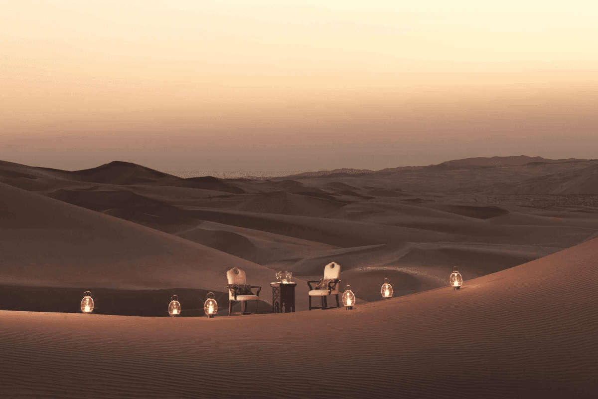 Table élégamment dressée dans le désert de Dubaï au coucher du soleil