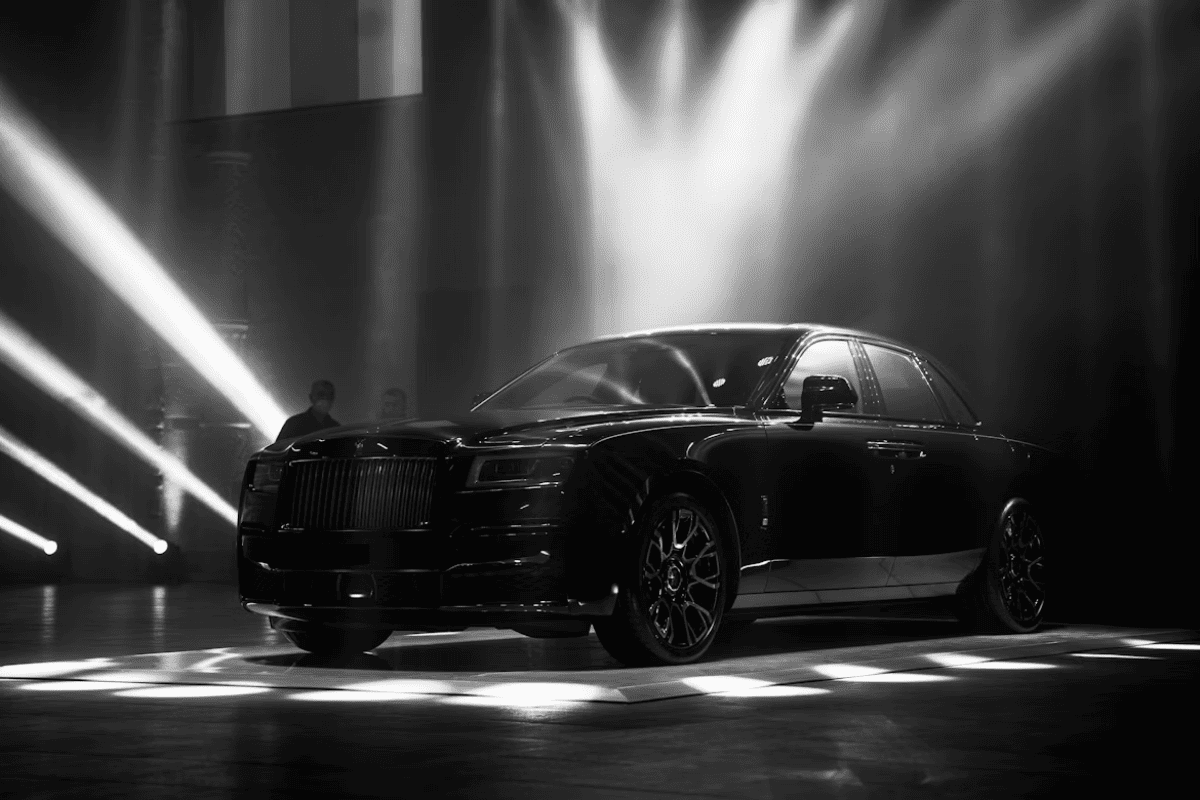 Rolls Royce noire exposée sous des lumières dans un lieu prestigieux